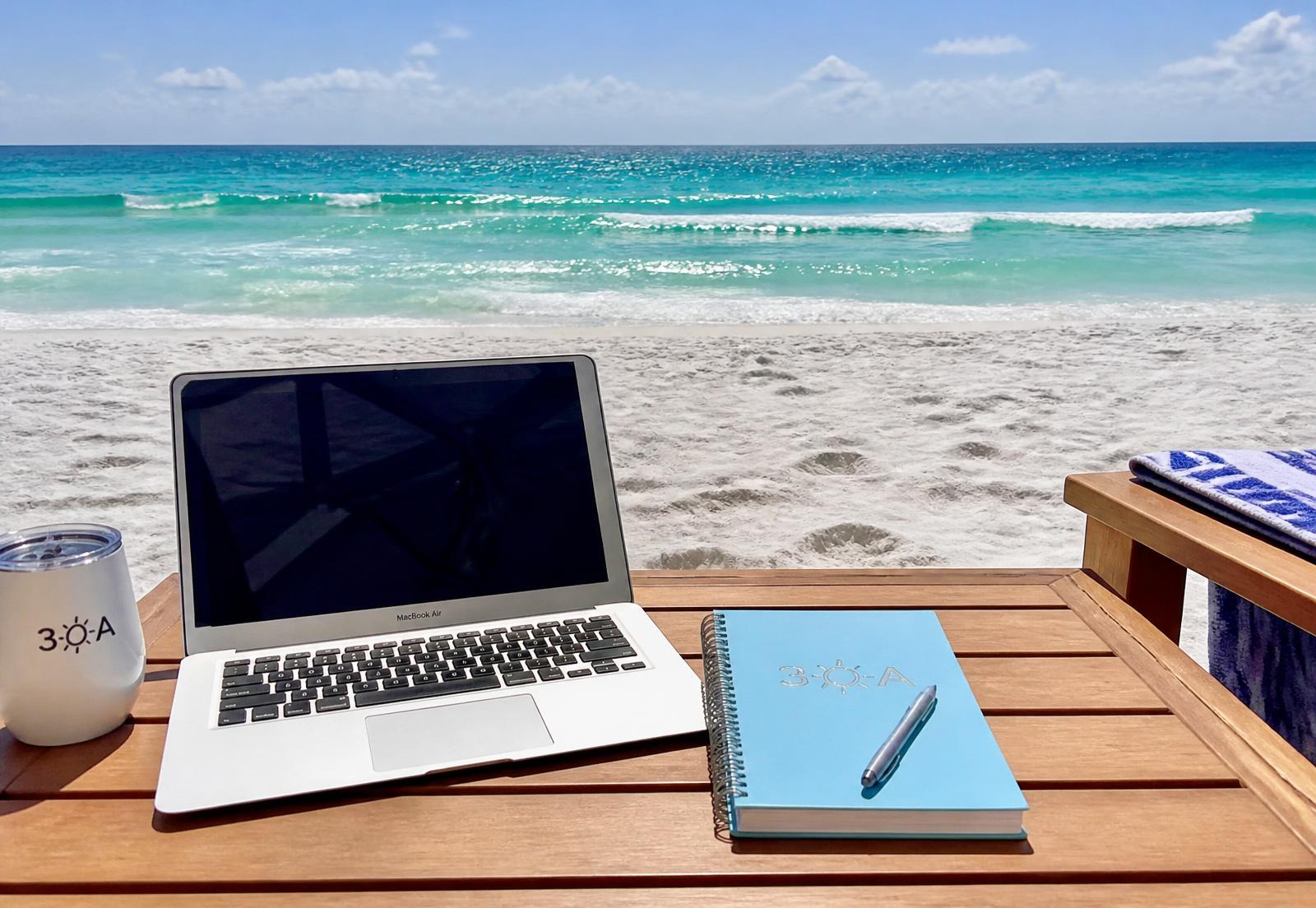 Laptop on a beach table overlooking the emerald water in Destin, Florida